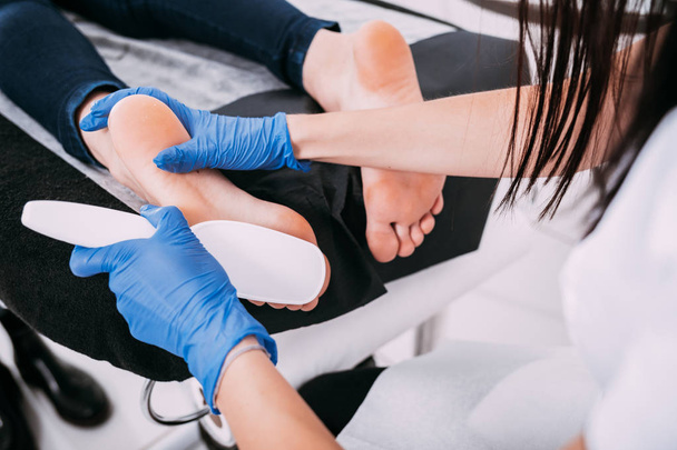Peeling feet pedicure procedure at cosmetic salon - Foto, afbeelding