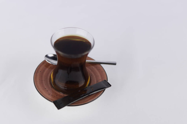 une tasse de thé sur un sucre blanc moulu et une cuillère
 - Photo, image