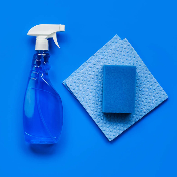 Transparent blue sprayer with window cleaner, rags and sponge on blue background. The view from the top. - Φωτογραφία, εικόνα