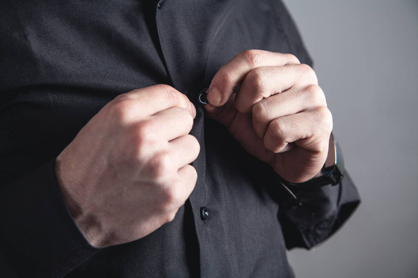 Man fastening button on shirt. - Foto, Bild