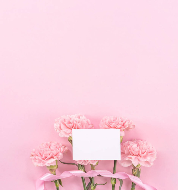 Top view, flay lay, copy space, close up, mock up, mothers day thanks design concept. Beautiful fresh blooming baby pink color carnations isolated on bright pink background - Фото, изображение