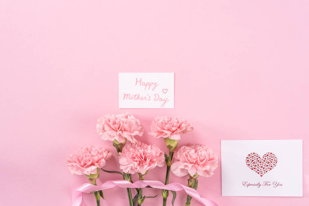 Top view, flay lay, copy space, close up, mock up, mothers day thanks design concept. Beautiful fresh blooming baby pink color carnations isolated on bright pink background - Foto, afbeelding