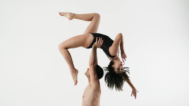 Танцевальная тренировка, мужчина поднял девушку на руки, держа ее за талию
 - Фото, изображение