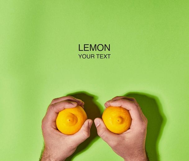 Diseño creativo hecho de limón en la mano sobre fondo verde. Piso tendido, vista superior, espacio para copiar. Concepto alimenticio
. - Foto, imagen