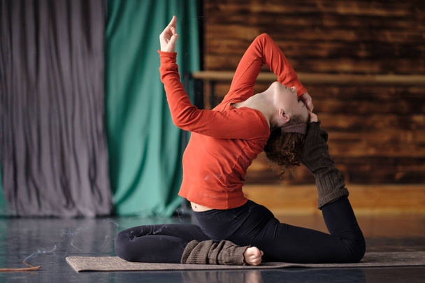 junge sportliche Frau praktiziert Yoga, macht Eka Pada Rajakapotasana Pose - Foto, Bild