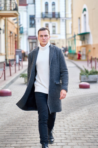 Young attractive hipster man wearing a gray coat, white sweater  - Фото, зображення