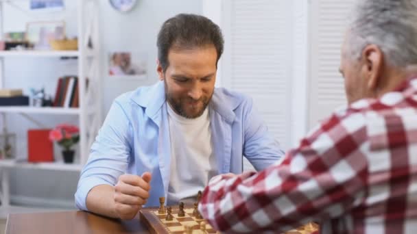 Adult males playing chess, father and son competing, hobby and leisure activity - Imágenes, Vídeo