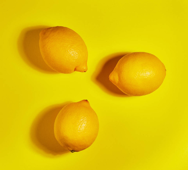 黄色の背景にレモン。フラットレイ、トップビュー、コピースペース。食品コンセプト. - 写真・画像
