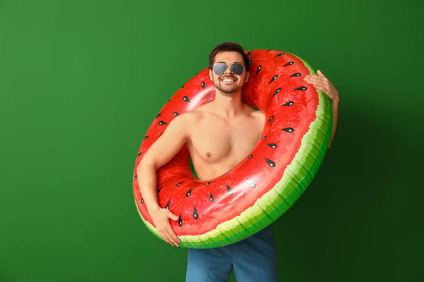 Handsome man with inflatable ring on color background - Фото, зображення