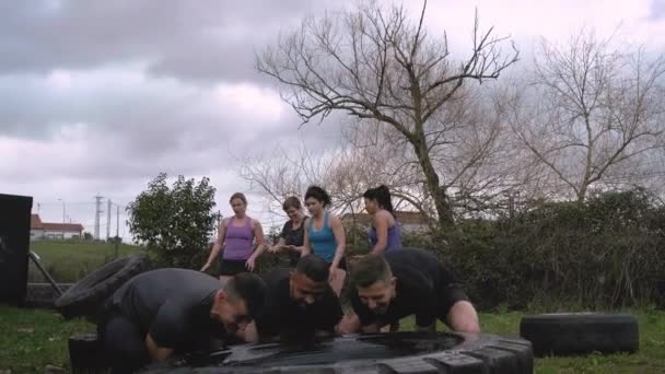 Participantes en una carrera de obstáculos girando una rueda
 - Metraje, vídeo