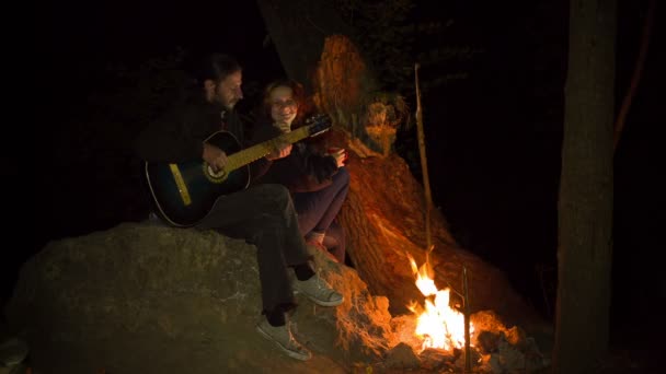 Genç çift bonfire at gitar oynuyor - Video, Çekim