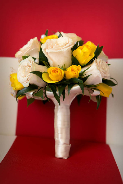 Bridal bouquet of white and yellow roses stands on a striped red background - Zdjęcie, obraz