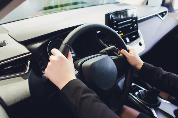 Woman driving a car, hands on steering wheel close-up. - Foto, Imagem