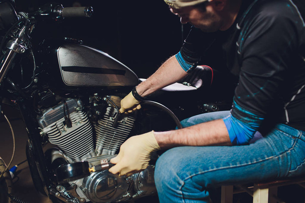 Man fixing bike. Confident young man repairing motorcycle near his garage. barometer - Foto, afbeelding