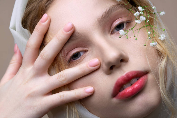 Model with natural makeup posing with plant near face - Photo, image