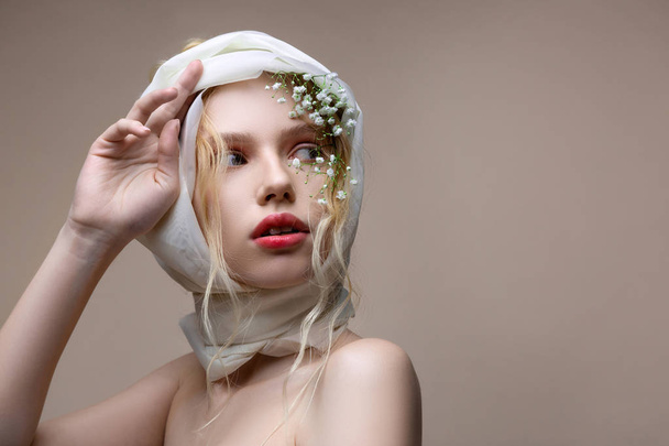 Blue-eyed model natural makeup posing with flowers in hair - Fotoğraf, Görsel