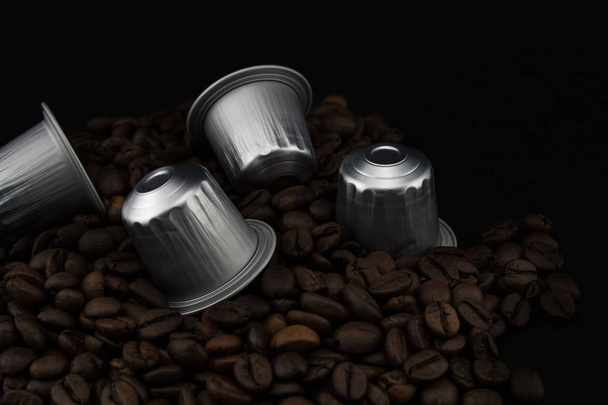 Kávové Kapsle nebo kávové lusky na kávových bobech, černé pozadí. - Fotografie, Obrázek