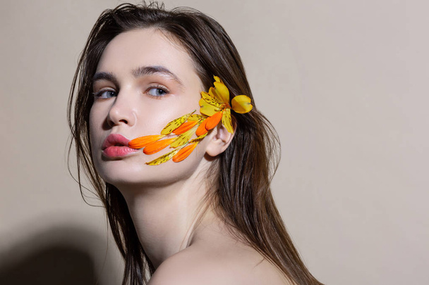 Appealing woman having flower in hair and feathers on face - Foto, Imagem