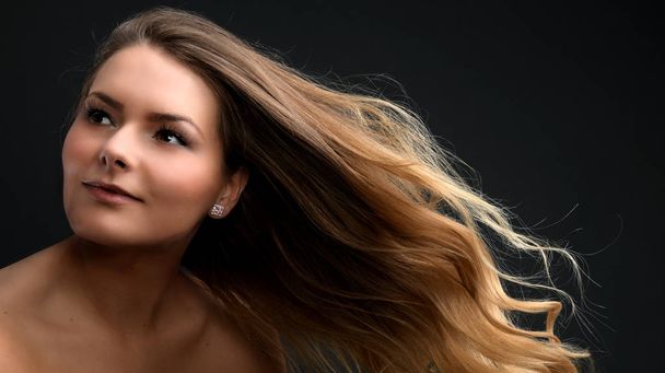 Schöne lächelnde Frau mit sauberer Haut, natürlichem Make-up und weißen Zähnen auf grauem Hintergrund  - Foto, Bild