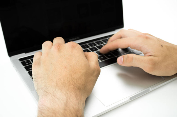 Üzleti személy segítségével a billentyűzet a laptop egy fehér asztalon. Dolgozó személy. - Fotó, kép
