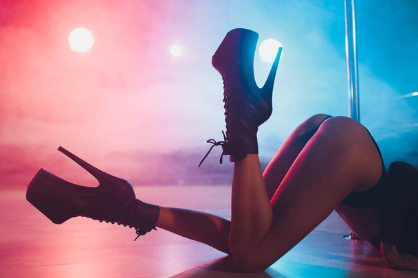 young striptease dancer moving in high heels shoes on stage in strip night club, Pole dancing. - Fotó, kép