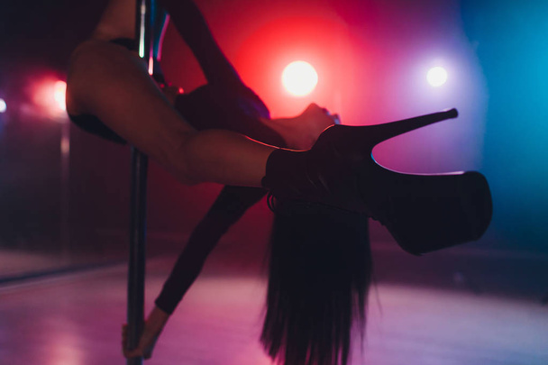 young striptease dancer moving in high heels shoes on stage in strip night club, Pole dancing. - 写真・画像