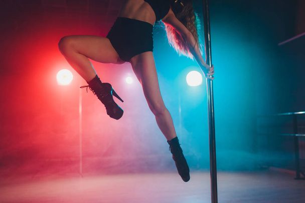 young striptease dancer moving in high heels shoes on stage in strip night club, Pole dancing. - Foto, afbeelding