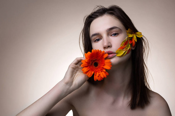 Blue-eyed model posing for nature campaign posing with flowers - Foto, afbeelding