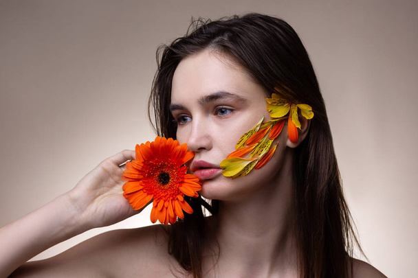 Dark-haired model showing poses with petals on face - Fotó, kép