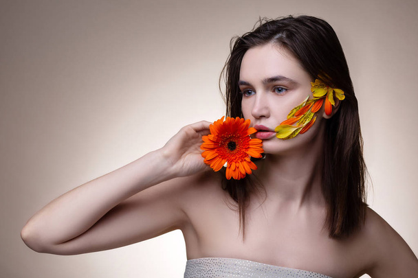 Tender model wearing open shoulder dress posing with flowers - Foto, Imagem