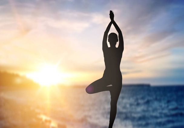 silhouette de femme faisant du yoga sur le coucher du soleil de mer
 - Photo, image