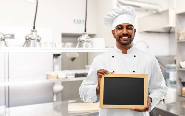 indian chef with chalkboard at restaurant kitchen - Foto, Imagen