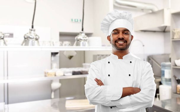 happy indian chef in toque at restaurant kitchen - Zdjęcie, obraz