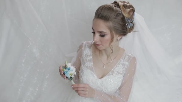 Bruid in trouwjurk met kleine boeket in de hand. Mooie en goed verzorgde vrouw - Video