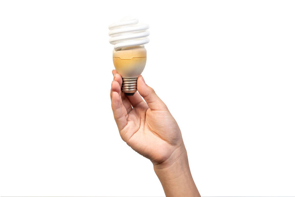 Енергозберігаючі спіральні лампочки або люмінесцентні лампи спіральної трубки ізольовані на білому тлі. Рука тримає стару і використовувану компактну люмінесцентну лампу для економії енергії
. - Фото, зображення