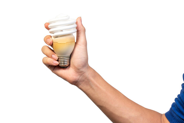 Energiesparende Spirale Twister Glühbirne oder Spiralröhre Leuchtstofflampe isoliert auf weißem Hintergrund. Hand hält alte und gebrauchte Kompaktleuchtstofflampen zum Energiesparen. - Foto, Bild