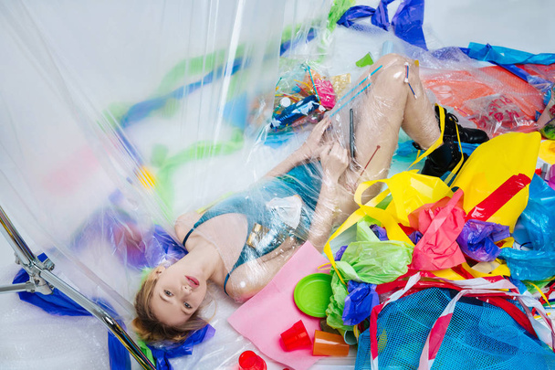 Top view of slim model wrapped into plastic lying on the floor - 写真・画像