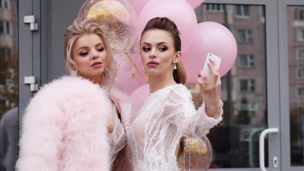 Dwie piękne i seksowne dziewczyny biorą selfie z balonem. - Materiał filmowy, wideo