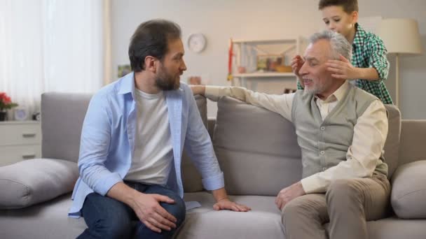 Father and son making birthday surprise for senior grandpa, giving gift box - Filmagem, Vídeo