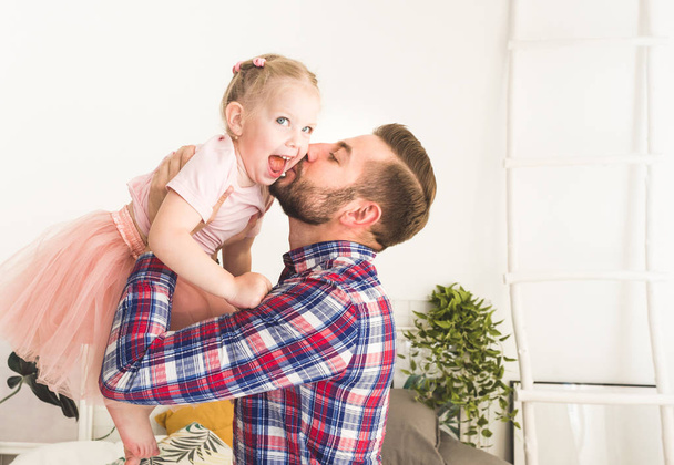 Cute little girl and her dad are having fun at home. - Photo, image