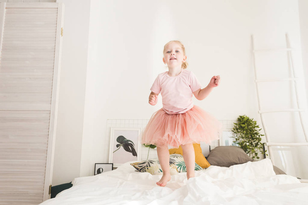 Cute little girl have fun on the bed at home. - Fotó, kép