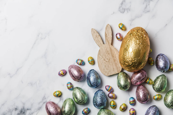 Easter bunny with foil wrapped chocolate easter eggs - 写真・画像