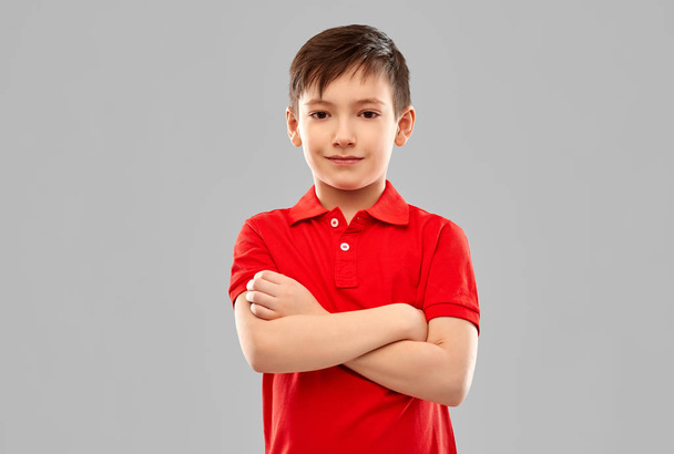 mosolygós fiú piros pólóban, keresztkaron - Fotó, kép