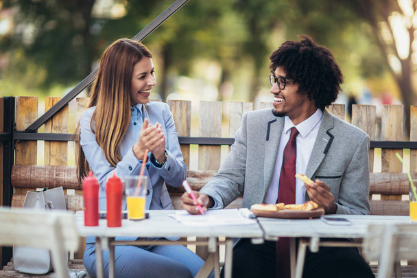 Feliz equipo de negocios jóvenes comiendo pizza en la cafetería al aire libre.Negocio
, - Foto, imagen