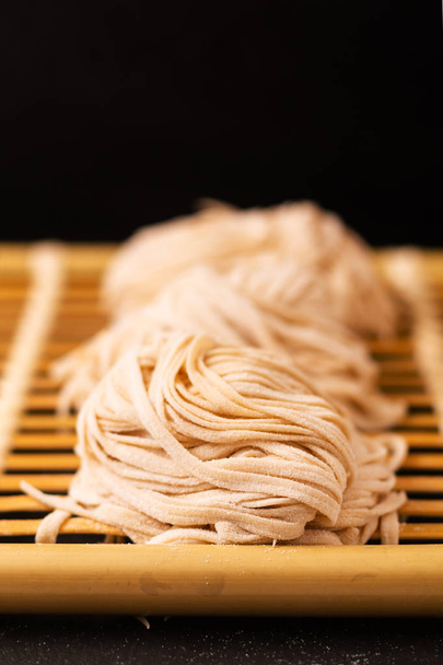 Asian Food concept homemade uncook oriental egg noodles on bambo - Foto, Imagem