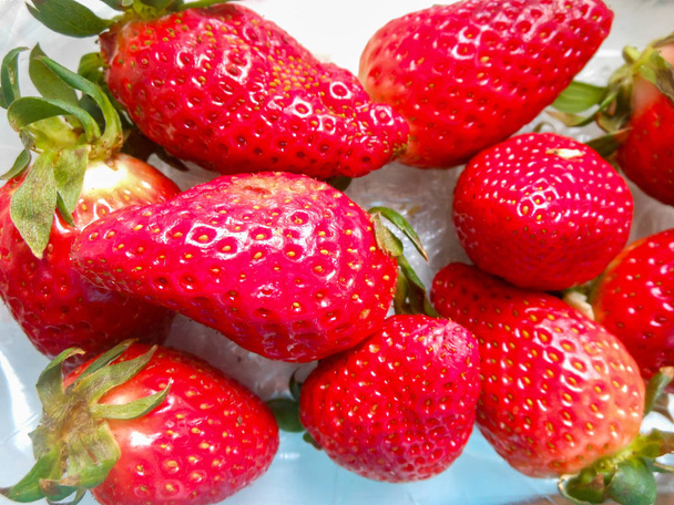 Μεγάλες κόκκινες ώριμες φράουλες σε λευκό φόντο την άνοιξη - Φωτογραφία, εικόνα