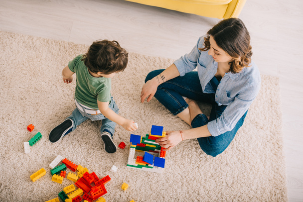 High angle view of mom and son playing with toy blocks in living room - Foto, Bild