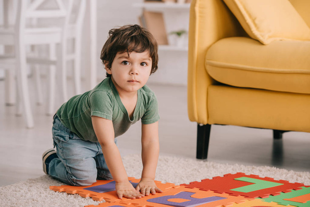 mignon enfant en t-shirt vert jouer avec tapis de puzzle
 - Photo, image