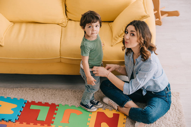 mother and son with alphabet puzzle mat in living room - Fotoğraf, Görsel