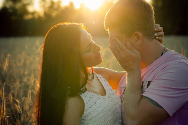 kaunis nuori pari auringonlaskun aikaan kesällä
 - Valokuva, kuva